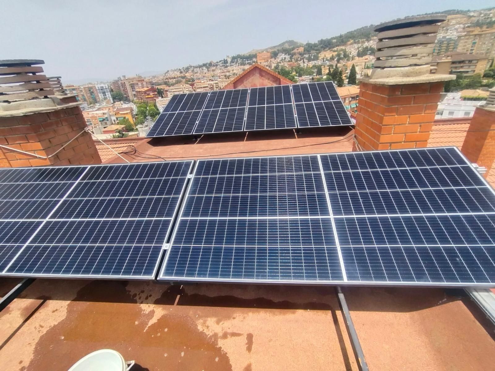 Grupos de paneles solares inclinados entre chimeneas de una azotea