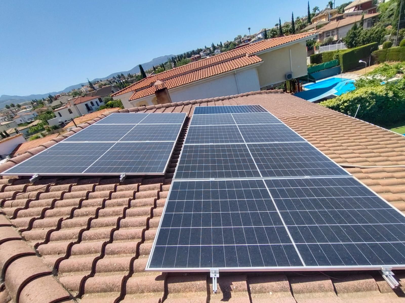 Dos grupos de paneles solares montados sobre una cubierta inclinada de teja
